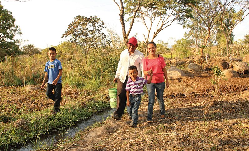 Luis (far left), Jaime, Angel and Reina gather water near their home in Honduras. Reina’s life was thrown into chaos when her husband Luis died in a motorcycle crash. Thanks to Randy and Pam Brown, who sponsor Luis and Angel through Unbound, Reina was able to survive the tough times. She has since married Jaime.  