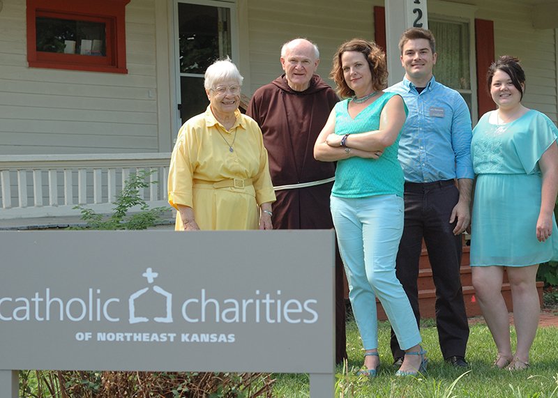 Built in 1880, this Lawrence home was renovated by St. John the Evangelist parishioners and donated as an emergency assistance center to Catholic Charities of Northeast Kansas. Standing in front (from left) are Ursuline Sister Marcella Schrant, Father Mike Scully, OFM Cap., Nickie Daneke, Eric Fitzmorris and Fran Pack.