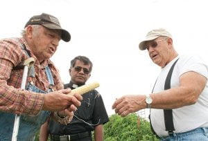 DeMaranville shares some of his corn with pastor Father Mathew Francis and Don Navinsky, parish council vice president.