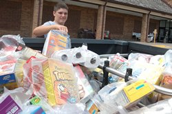 Leaven photo by Jill Ragar Esfeld St. James Academy freshman Jake Thies, a member of Holy Trinity Parish in Lenexa, adds another bag of groceries to the donations he helped collect for Catholic Charities food pantry.