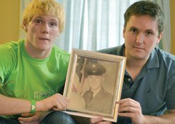 Tyler (left) and Ryan Kruskamp display a photo of their father Larry, who died of cancer last fall. Larry chose Catholic Community Hospice because of its faith component, and his sons found in the agency the support system they so desperately needed during their darkest hours.