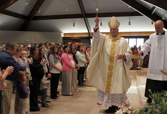 LEAVEN PHOTO BY SUSAN MCSPADDEN Archbishop Joseph F. Naumann blesses a group of expectant mothers and their families during the archdiocese’s inaugural celebration of the Rite for the Blessing of a Child in the Womb on April 20 at Holy Spirit Church in Overland Park.