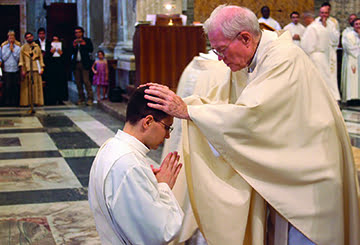 Father Michael Mullen, co-director of seminarians for the archdiocese, participates in the ancient rite of laying on of hands on Father Alessandro Borraccia, AVI, the newest priest for the archdiocese. Father Alessandro was ordained June 23 at the Basilica of St. Paul Outside the Walls in Rome. Photo courtesy of Father Alessandro Borraccia 