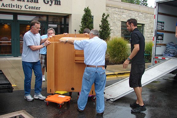 Nativity director of ministries Tom Garbach (left) and Knights of Columbus members load the heavy ambo onto a truck bound for Joplin, Mo. The ambo, along with other altar furniture, was donated to St. Mary Parish in Joplin, which was destroyed in a tornado.