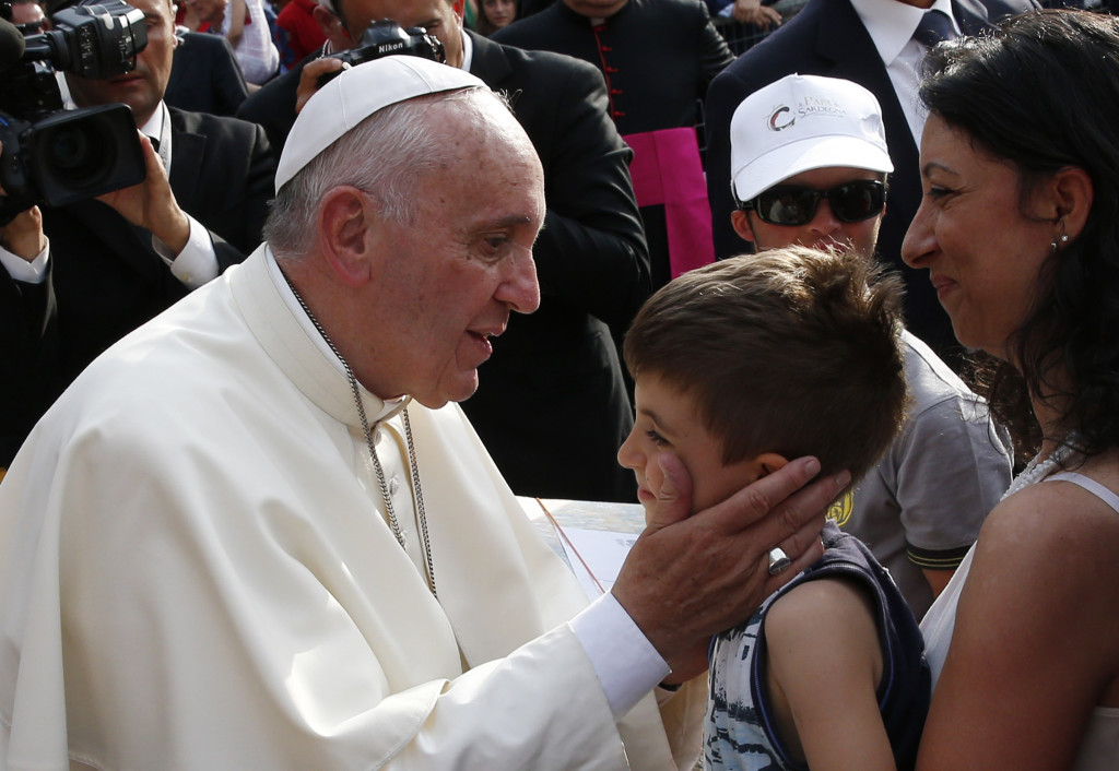 Pope Francis greets a boy during a gathering with young people in Piazza Vittorio in Turin, Italy, June 21. (CNS photo/Paul Haring) See POPE-TURIN June 22, 2015.