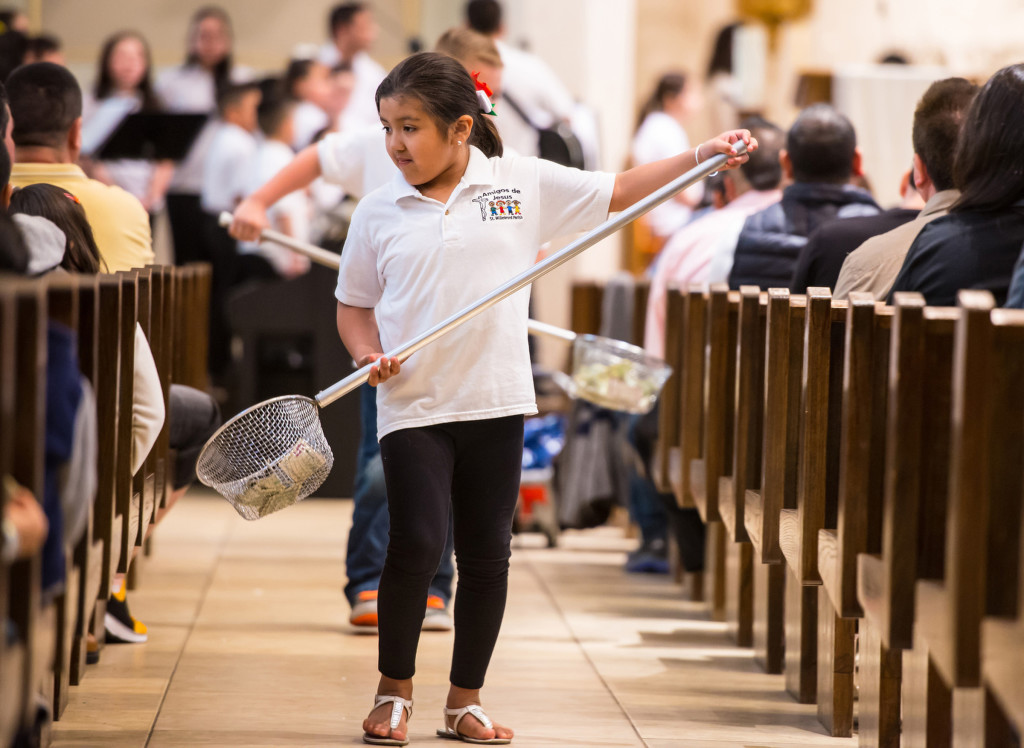 Hispanic Youth Group member Yelixa Hernandez helps collect donations during Mass at St. Willebrord Church in Green Bay, Wis., April 26. (CNS photo/Sam Lucero, The Compass)