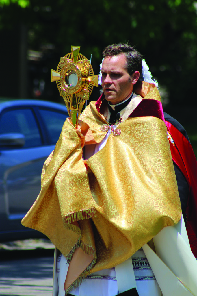 Father Greg Hammes, pastor of Most Pure Heart of Mary Parish in Topeka, leads an outdoor eucharistic procession in celebration of the parish’s 25th anniversary of perpetual adoration. By Marc Anderson