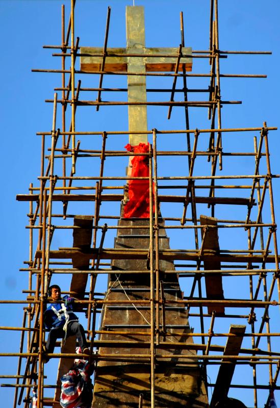 In this 2010 file photo, a worker climbs scaffolding surrounding a church in Qingdao, China. Two excommunicated bishops in China have ordained priests in separate ceremonies during the past two months. (CNS photo/Wu Hong, EPA)  