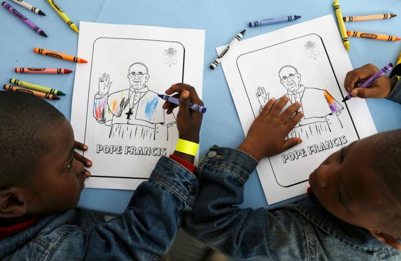 Kaydn Dorsey, 4, (left) and Lionel Perkins, 4, color images of Pope Francis as they wait for him to arrive for a visit to Catholic Charities of the Archdiocese of Washington Sept. 24 in Washington. (CNS photo/David Goldman, pool) 