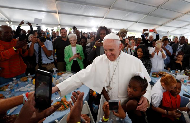 A girl hugs Pope Francis as he visits with people at St. Maria's Meals Program of Catholic Charities in Washington Sept. 24. (CNS photo/Paul Haring) 