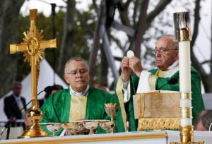 Pope Francis raises the Eucharist as he celebrates the closing Mass of the World Meeting of Families on Benjamin Franklin Parkway in Philadelphia Sept. 27. With him at the altar is Philadelphia Archbishop Archbishop Charles J. Chaput. (CNS photo/Paul Haring)