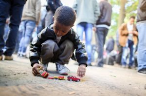 Refugee boy plays with a toy car while refugees wait for registration in Berlin,ÊGermany, Oct. 1. (CNS photo/Kay Nietfeld, EPA)
