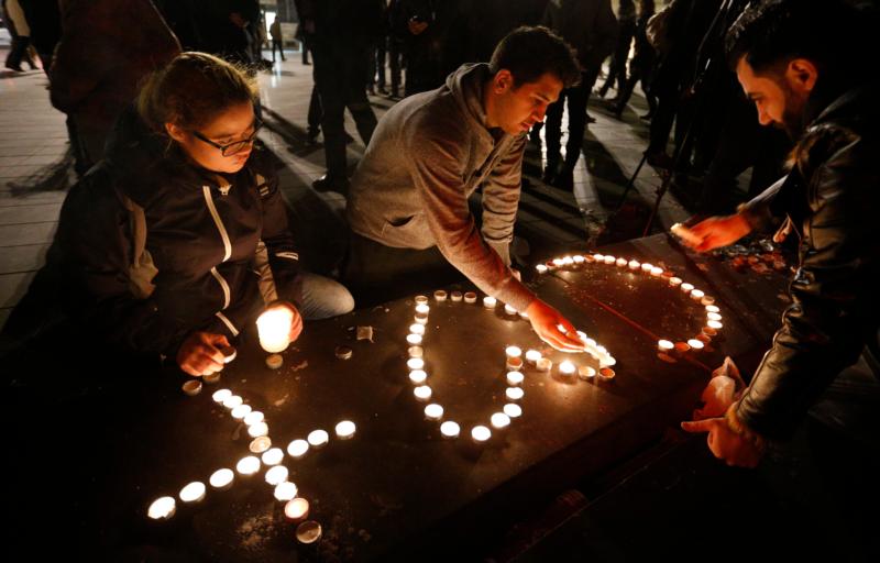 People light candles in the shape of a cross and heart in Republique square in Paris Nov. 14 in memory of victims of terrorist attacks. Coordinated attacks the previous evening claimed the lives of 129 people. The Islamic State claimed responsibility. (CNS photo/Paul Haring)