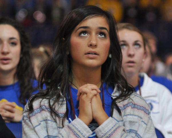 Alaina Sincich, a member of St. John Neumann Parish in Sunbury, Ohio, kneels in prayer Nov. 21 during the closing Mass of the National Catholic Youth Conference at Lucas Oil Stadium in Indianapolis. The Mass was attended by 23,000 youths from across the country. (CNS photo/Sean Gallagher, The Criterion)