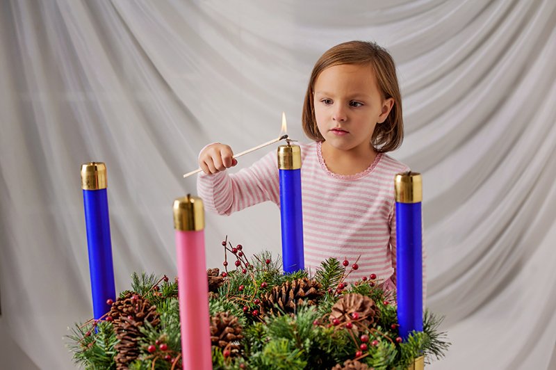 Mary Nearmyer, 5, lights the first candle on the traditional Advent wreath. Mary is the daughter of Deacon Dana and Debbie Nearmyer, members of Holy Trinity Parish, Lenexa. Advent begins on Nov. 29. Photo by Lori Wood Habiger