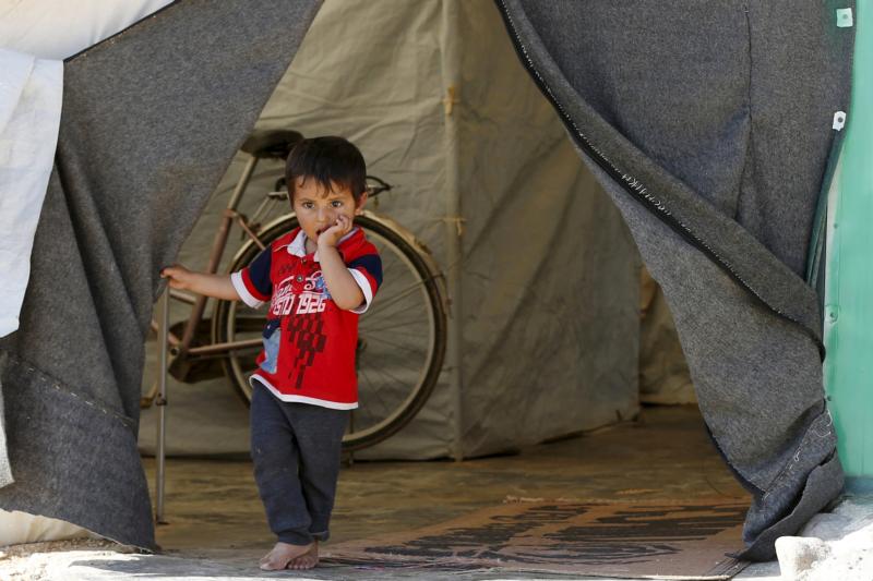 A Syrian refugee boy stands in front of his family's tent in late November at a camp in the Jordanian city of Mafraq, near the border with Syria. (CNS photo/Muhammad Hamed, Reruters)
