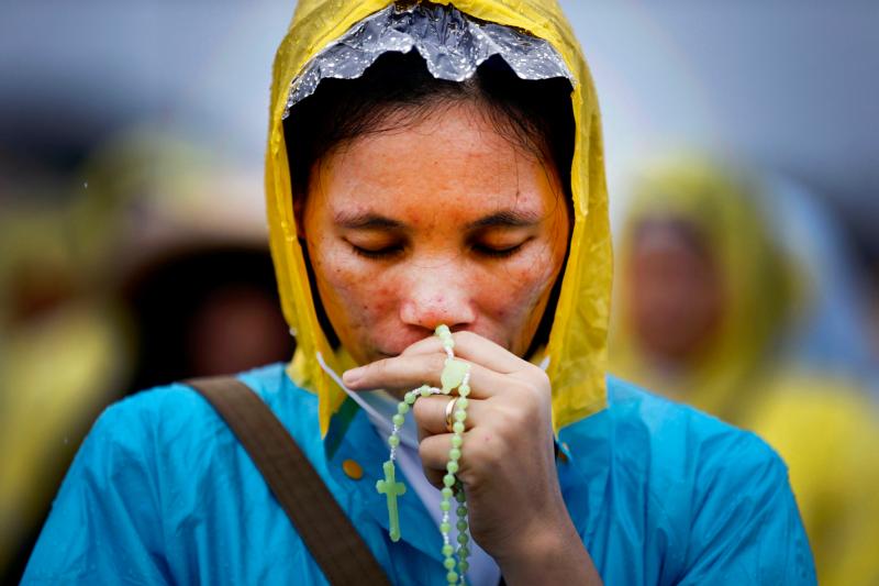 A woman prays in 2015 as Pope Francis celebrates Mass in Manila, Philippines. The prayers of the faithful, not the pope, bishops, priests or nuns, have the power to make miracles happen in the most impossible situations, Pope Francis said at his morning Mass. (CNS photo/Dennis M. Sabangan, EPA)