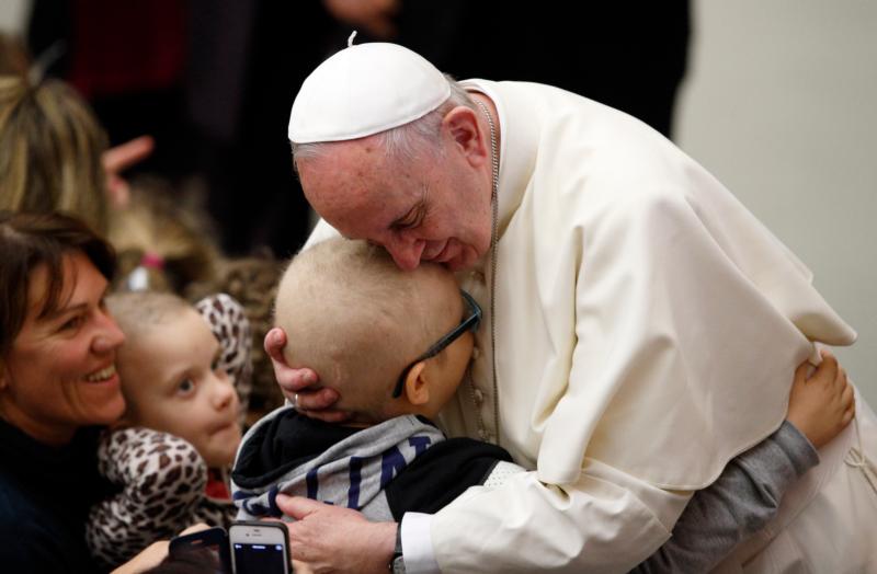 Pope Francis embraces a child as he meets the disabled during his general audience in Paul VI hall at the Vatican Jan. 13. (CNS photo/Paul Haring)