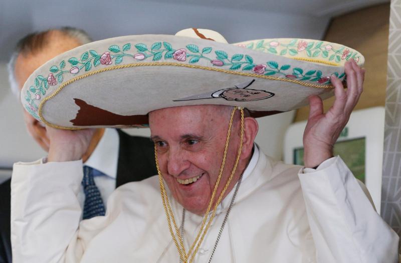 Pope Francis tries on a sombrero while meeting journalists aboard his flight to Havana Feb. 12. Traveling to Mexico for a six-day visit, the pope is stopping briefly in Cuba to meet with Russian Orthodox Patriarch Kirill of Moscow at the Havana airport. (CNS photo/Paul Haring)