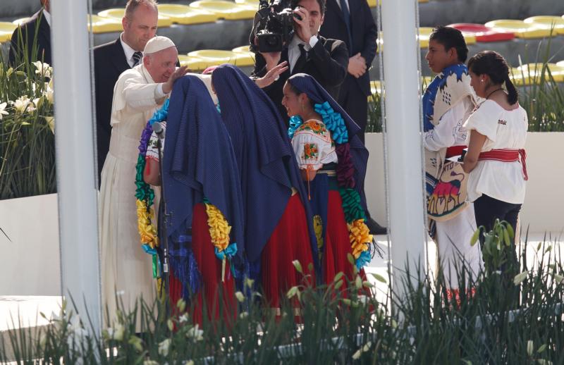 Pope Francis greets girls in traditional dress during a meeting with young people at the Jose Maria Morelos Pavon Stadium in Morelia, Mexico, Feb. 16. (CNS photo/Paul Haring)