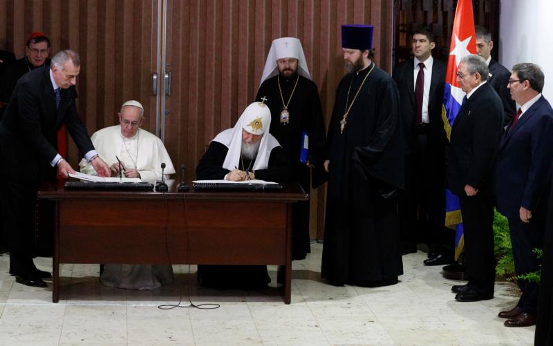 Pope Francis and Russian Orthodox Patriarch Kirill of Moscow sign a joint declaration during a meeting at Jose Marti International Airport in Havana Feb. 12. Standing in front of Cuba's flag is Cuban President Raul Castro. (CNS photo/Paul Haring)
