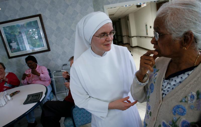 A member of the Little Sisters of the Poor assists a woman at the Little Sisters' Jeanne Jugan Residence in Washington in this 2009 photo. (CNS file photo)