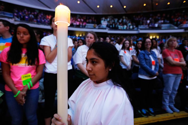 A girl carries a candle during a Feb. 24 Mass at the 2016 Los Angeles Religious Education Congress at the Anaheim Convention Center in California. (CNS photo/Victor Aleman)