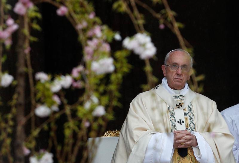 Pope Francis is pictured through flowers as he celebrates Easter Mass in St. Peter's Square at the Vatican in this April 5, 2015, file photo. As part of an ecological initiative, the Vatican announced that it will plant tulips from the 2016 Easter Sunday Mass in the Vatican Gardens and also give them to various pontifical colleges and institutions. (CNS photo/Paul Haring)