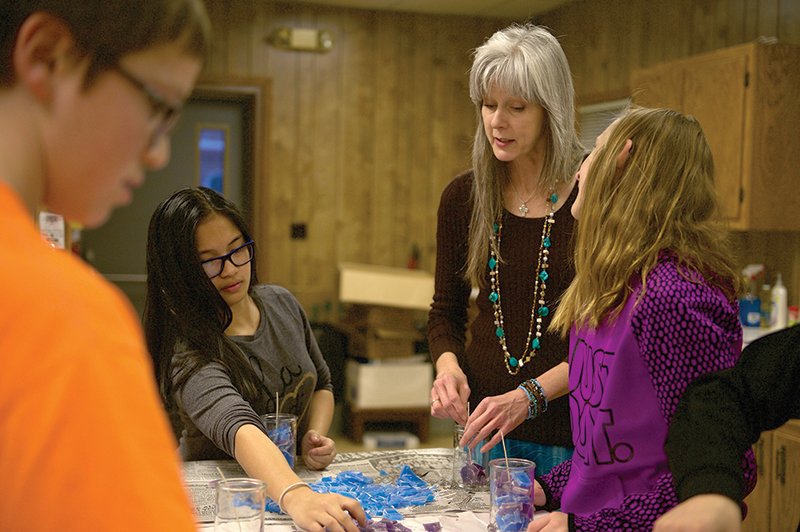 From left, Richard Leiker, Maxine Bertulfo, Angie McGuffin and Staci Bond make candles as part of McGuffin’s “Faith, Hope and Love” religious education program at St. Dominic Parish in Holton. “Faith, Hope and Love” teaches aspects of the faith through actions.