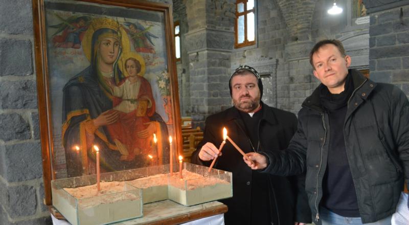 Syriac Orthodox Bishop Selwanos Alnemeh of Homs and John Pontifex of Aid to the Church in Need pose with candles in February at the Syriac Catholic Cathedral in Homs.  (CNS photo/Aid to the Church)