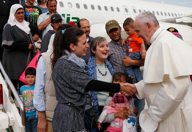 Pope Francis greets Syrian refugees he brought to Rome from the Greek island of Lesbos, at Ciampino airport in Rome April 16, 2016. The pope concluded his one-day visit to Greece by bringing 12 Syrian refugees to Italy aboard his flight. (CNS photo/Paul Haring)