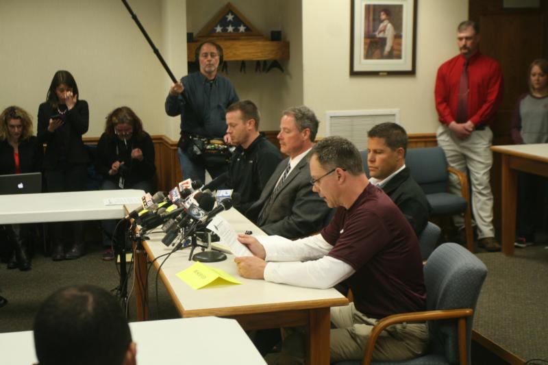 Principal Tom Zamzow of Antigo High School in Wisconsin, reads a statement during a press conference at Antigo City Hall April 25. The community is coping with a shooting at Antigo High School April 23 that left one young man dead adn two students injured. Also pictured are Brian Misfeldt, left, school district administrator-designate; Langlade County Sheriff Bill Greening and Antigo Police Chief Eric Roller. (CNS photo/Lisa Haefs, for The Compass)