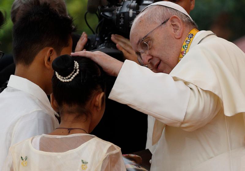 Pope Francis comforts Glyzelle Palomar, 12, after the former street child spoke during a meeting with young people at the University of St. Thomas in Manila, Philippines, in this Jan. 18, 2015, file photo. Also pictured is Jun Chura, 14, who also spoke. Palomar cried while giving her testimony, leading the pope to speak about the importance of tears. (CNS photo/Paul Haring)