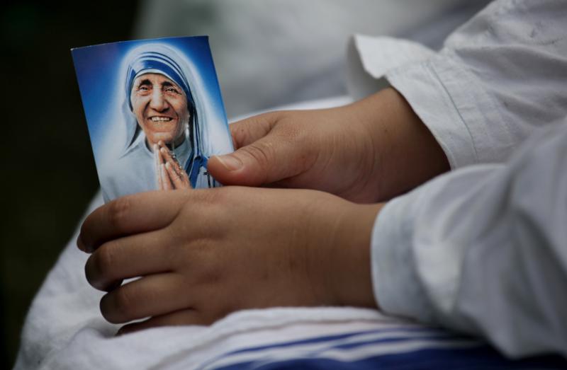 A nun from the Missionaries of Charity holds a picture of Blessed Teresa of Kolkata during a Mass to remember her in Kolkata, India, Sept. 4, 2011. Blessed Teresa will be canonized at the Vatican Sept. 4. (CNS photo/Piyal Adhikary, EPA)