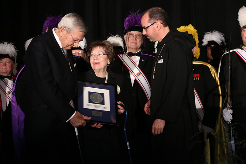 Abbot James Albers, OSB, and the monks of St. Benedict’s Abbey present the Lumen Vitae Medal to past Supreme Knight of Columbus Virgil Dechant and his wife Ann. 