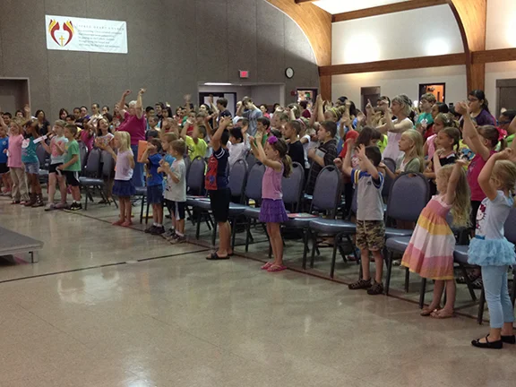Students at Sacred Heart Church in Emporia begin a day of intensive summer religious education with a song about Noah and the ark. Rather than the traditional religious education paradigm — where students attend class each week — students at Sacred Heart attend a two-week session each summer.
