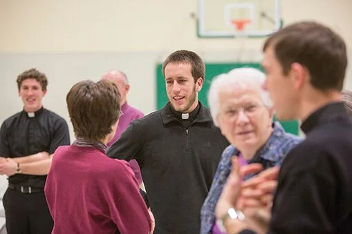 Chris McCoy, nSJ (center), visits with the parishioners at the Cathedral of St. Peter. McCoy and two other Jesuit novices provided a variety of spiritual services in the area during their six weeks in the archdiocese.